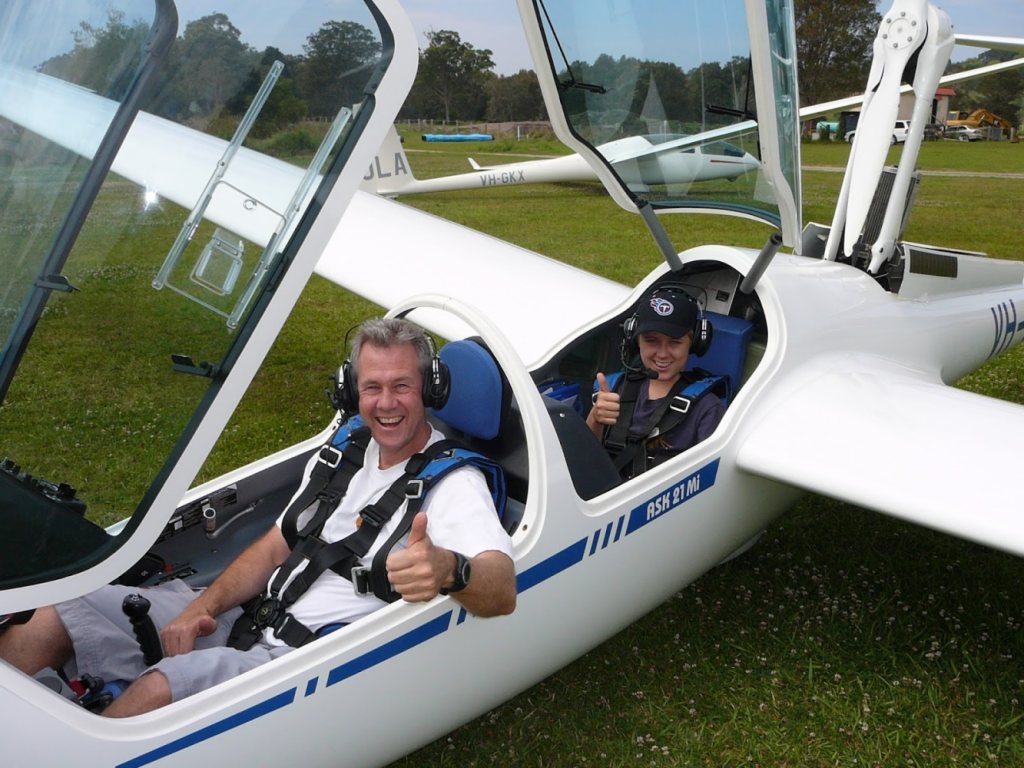 Guy grinning in the front seat of a two-seat glider, thumbs up